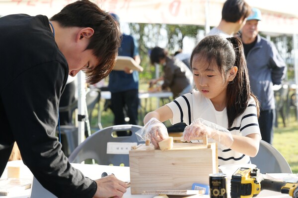 제10회 강진만 춤추는 갈대축제장을 찾은 한 어린이가 목재 체험을 하고 있다. (사진=강진군)