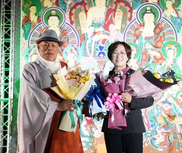 지난 28일 군동면 남미륵사 대웅전 앞마당에서 열린 ‘제34회 남미륵사 산사음악회’에서 법흥 주지스님이 강진군의회 유경숙 의원(운영위원장)에게 감사패를 수여한 후 함께 기념촬영을 하고 있다. (사진=강진군의회)